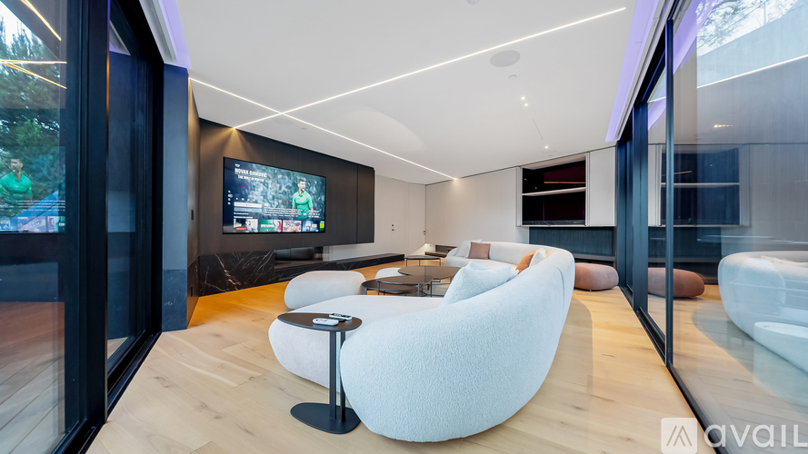 A modern living room with a large white chair and a television.