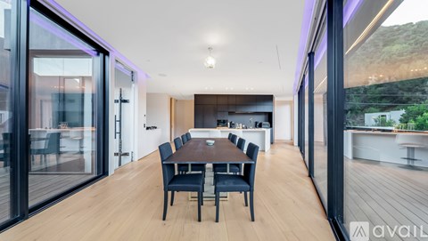 A modern dining room with a long table and chairs.