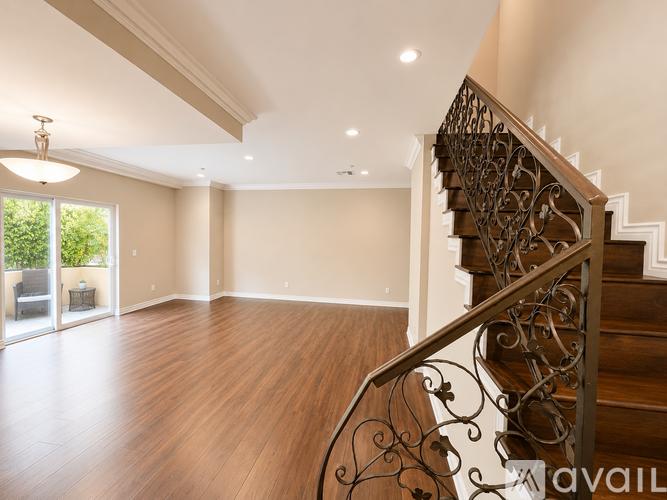 A staircase with a metal railing leads up to a second floor.