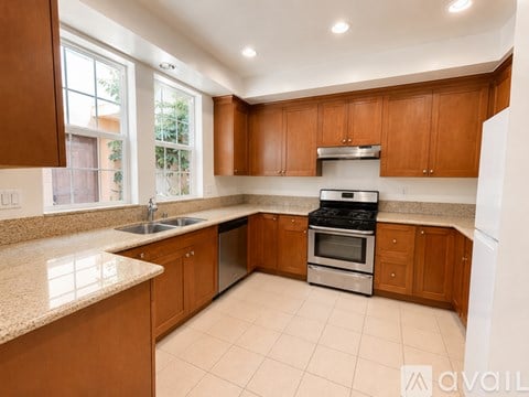 A kitchen with wooden cabinets and a granite countertop.