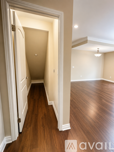 A hallway with wood floors and white walls.