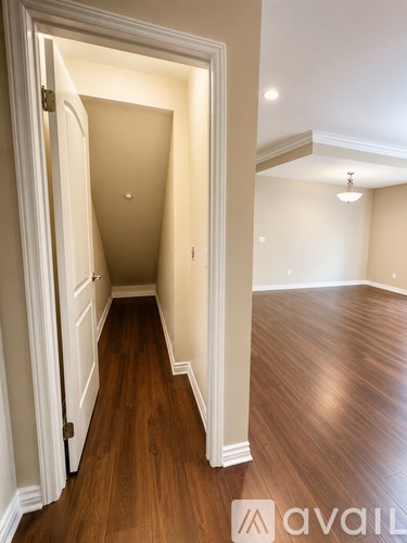 A hallway with wood floors and white walls.