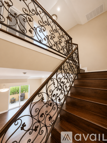 A staircase with a metal railing and wooden steps.