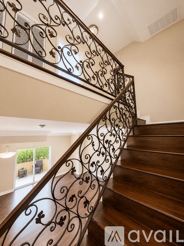 A staircase with a metal railing and wooden steps.