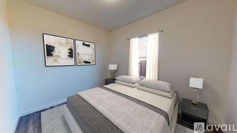 A bedroom with a large bed and two lamps.