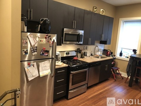 A kitchen with a refrigerator on the left and a microwave above the stove.