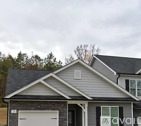 A house with a grey roof and a white garage door.