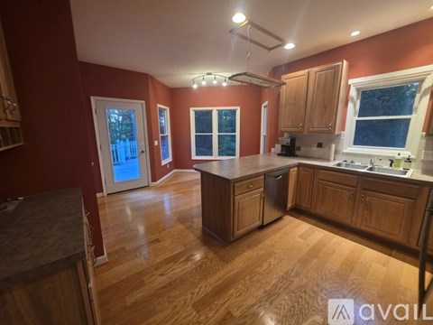 A kitchen with wooden cabinets and a large island in the middle.