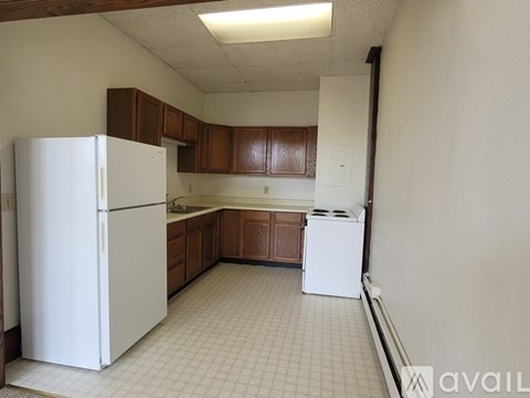 A kitchen with white appliances and brown cabinets.