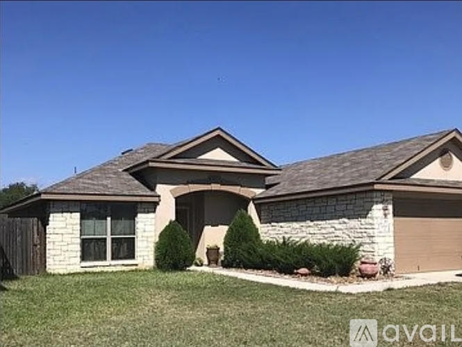 A house with a brown roof and a garage door is available for sale.