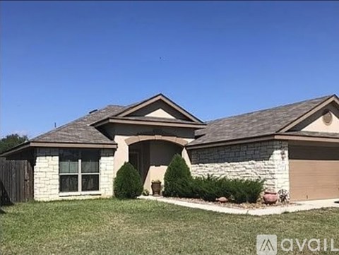 A house with a brown roof and a garage door is available for sale.