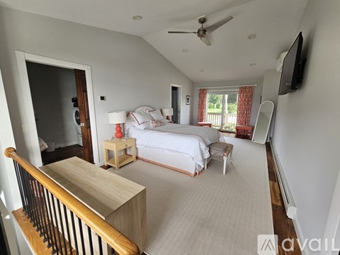 A bedroom with a bed, a nightstand, and a television.
