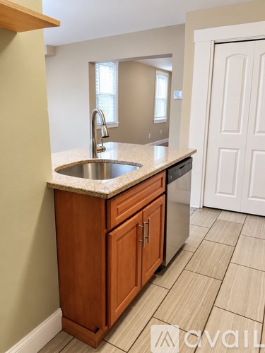 A kitchen with a sink and wooden cabinets.