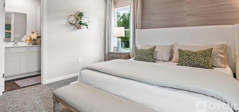 A bedroom with a large bed and a mirror on the wall.