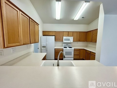 A kitchen with wooden cabinets and white appliances.