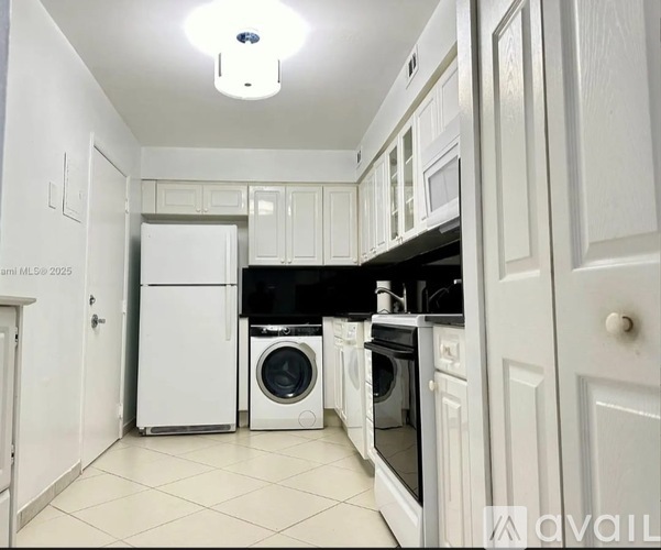 A kitchen with white appliances and cabinets.