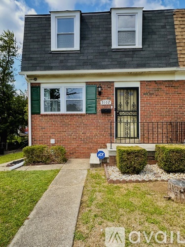 A brick house with a black window and a green window.