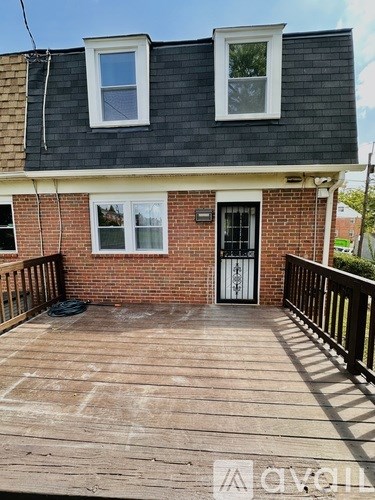 A small house with a wooden deck in front.