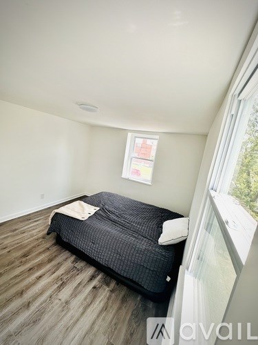 A bedroom with a bed and a window.
