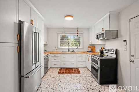 A kitchen with a refrigerator, stove, and oven.