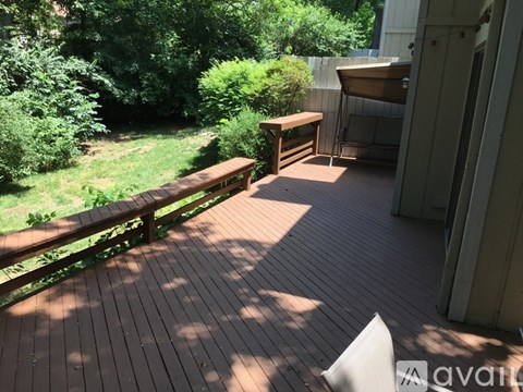 A wooden deck with a bench and a table.