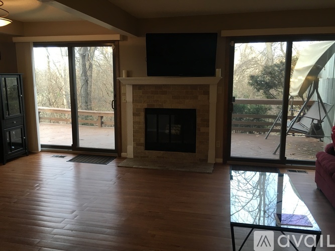 A living room with a fireplace and a television on the wall.