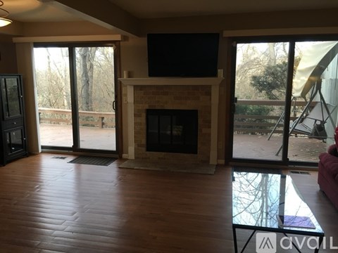 A living room with a fireplace and a television on the wall.
