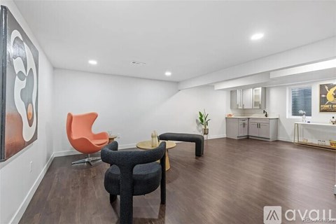 A living room with a black chair and a red chair.