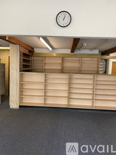 A wall with a clock and a shelf with drawers.