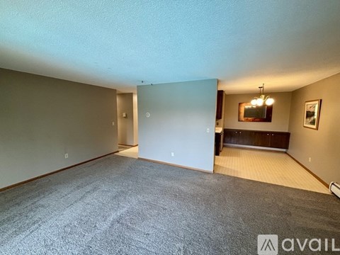 A spacious room with a carpeted floor and a bench against the wall.