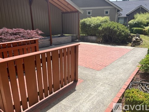 A wooden fence borders a red brick patio.