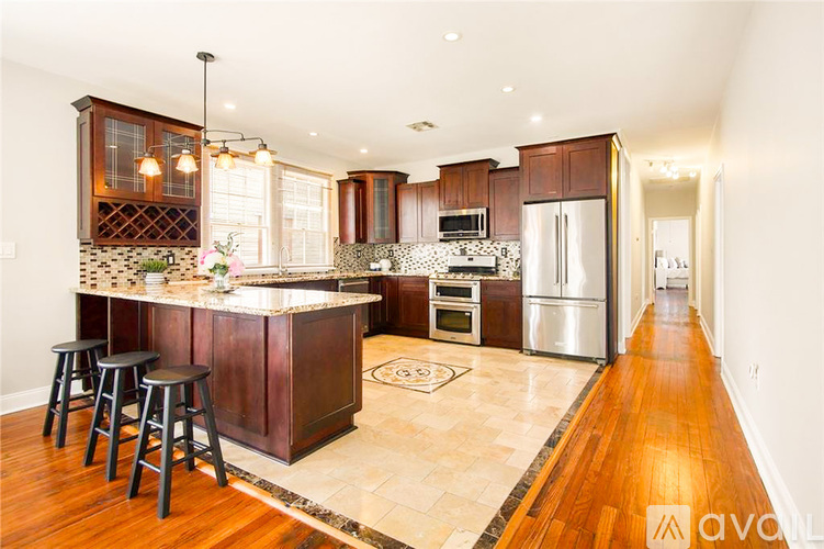 A kitchen with wooden cabinets and a marble backsplash.