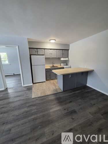 A kitchen area with a white refrigerator and cabinets.
