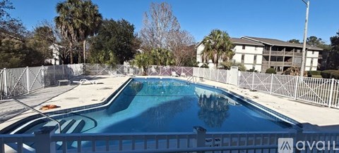 A pool surrounded by a fence with the word "AVAILABLE" written on it.