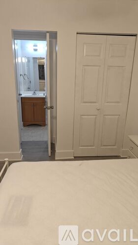 A bedroom with a white door and a bed in the foreground.