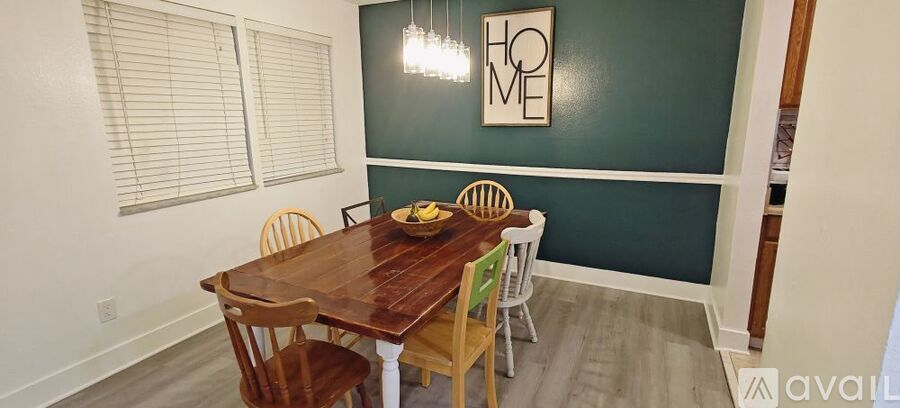 A dining room with a wooden table and chairs.