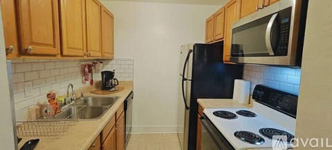 A kitchen with wooden cabinets and black appliances.