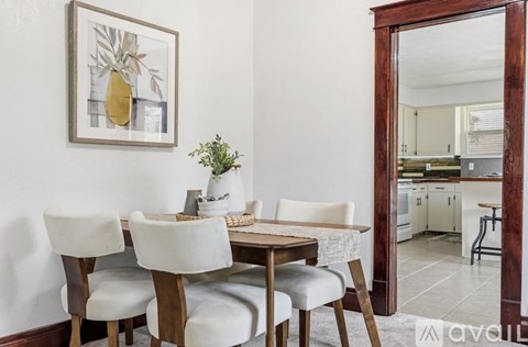 A dining room with a table set for four.