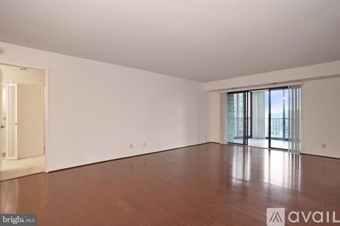 A spacious room with wooden floors and white walls.