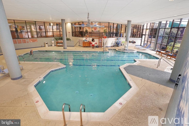 A large indoor swimming pool with a diving board.