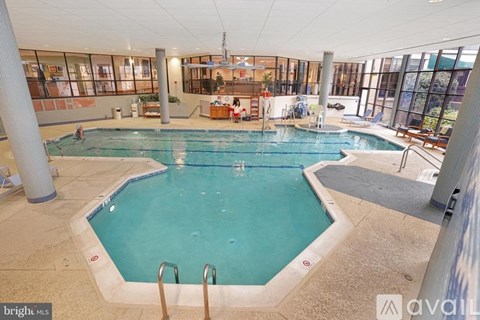 A large indoor swimming pool with a diving board.