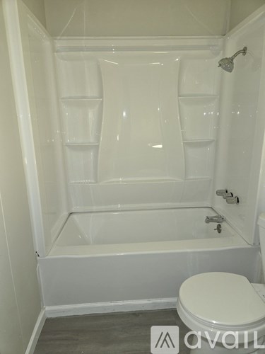 A white toilet sits next to a bathtub in a bathroom.