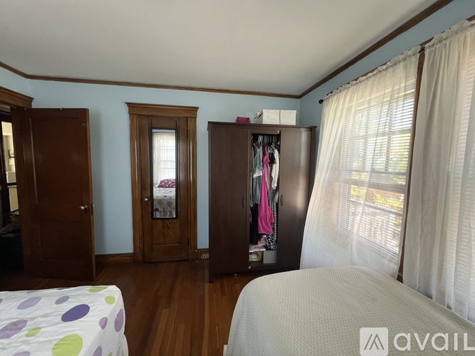 A bedroom with a bed, a wardrobe, and a window.