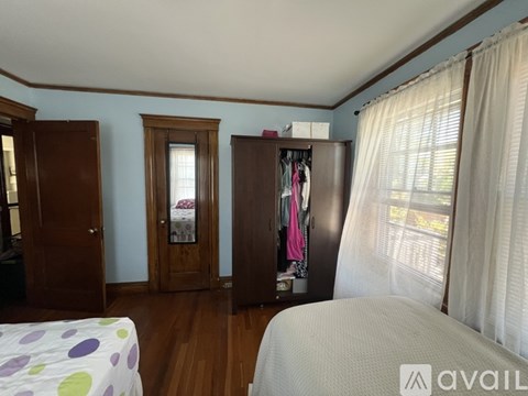 A bedroom with a bed, a wardrobe, and a window.