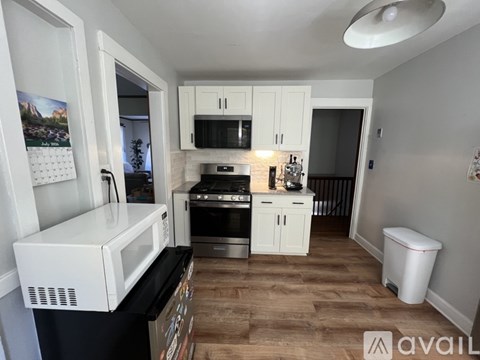 A kitchen with white cabinets and a white microwave oven.