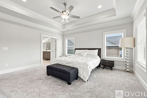 A bedroom with a large bed and a ceiling fan.
