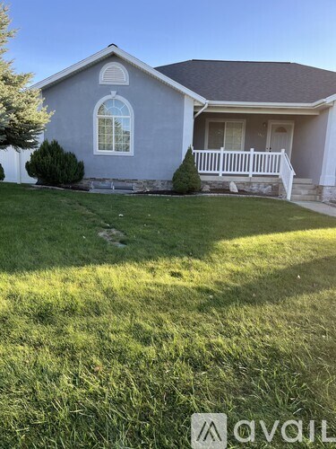 A house with a grey roof and white fence.