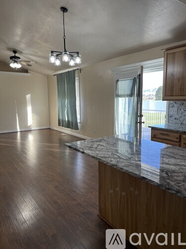 A spacious room with wooden floors and a marble countertop.