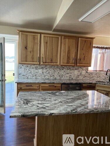 A kitchen with wooden cabinets and a marble countertop.