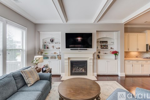 A living room with a fireplace and a television on the wall.